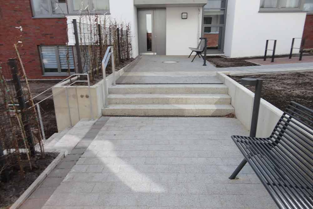 Eine Treppe führt zu einem Gebäude mit einer Bank davor