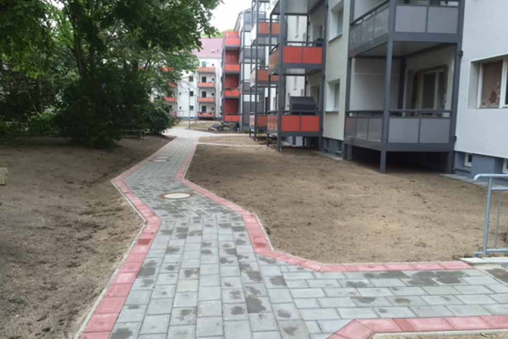 Vor einem Gebäude wird ein Gehweg gebaut.