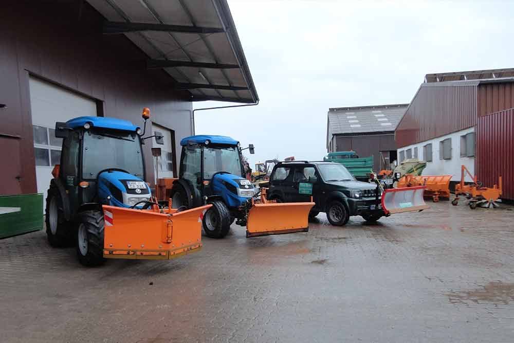 Eine Reihe von Traktoren parkte vor einem Gebäude.