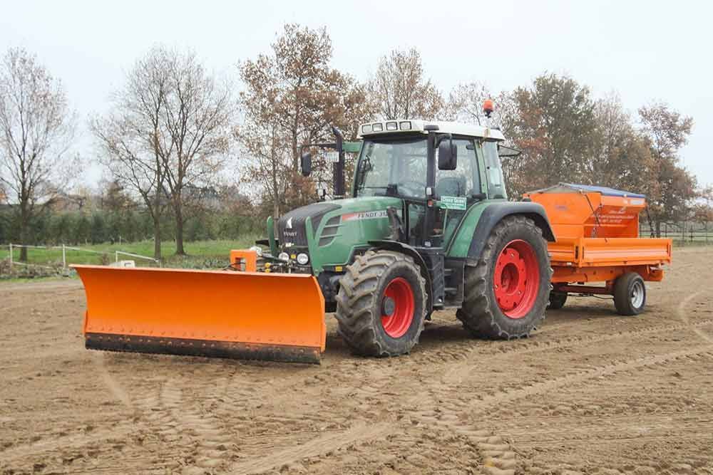 Ein Traktor mit daran befestigtem Pflug pflügt ein Feld.