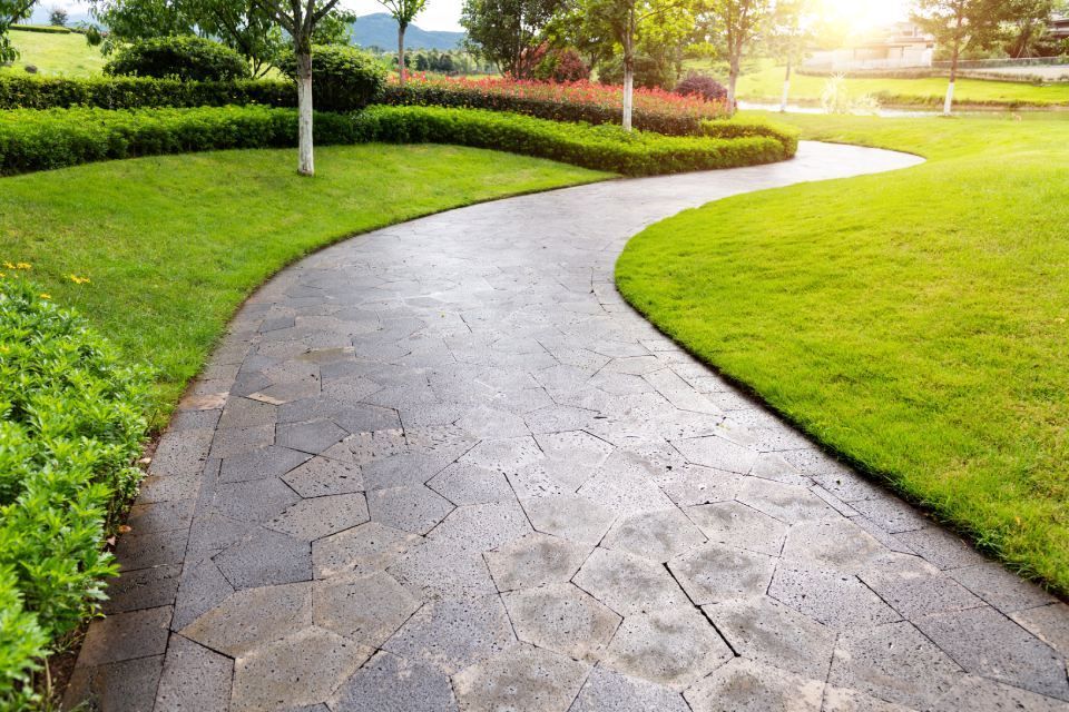 Ein Weg in einem Park mit viel Gras und Bäumen, Metallbau & Garten- & Landschaftsbau Ökmen