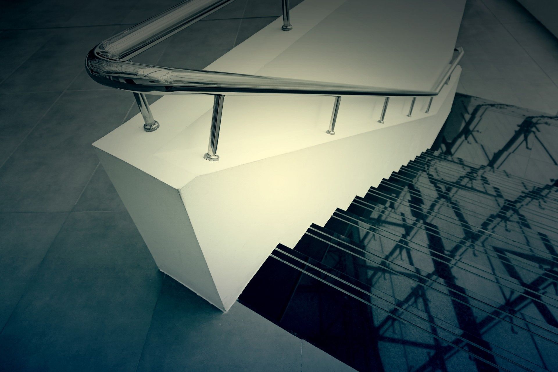 Eine Treppe mit einem Metallgeländer und der Spiegelung eines Gebäudes