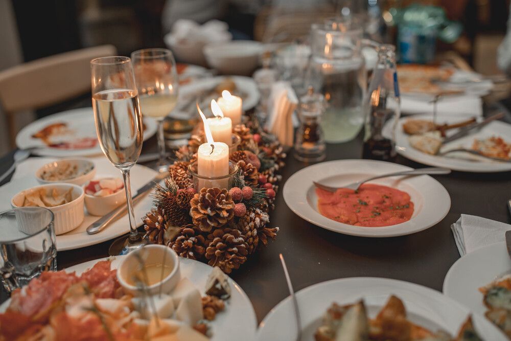 Elegante mesa para cenar con velas, flores, copas de vino y platos servidos para una comida