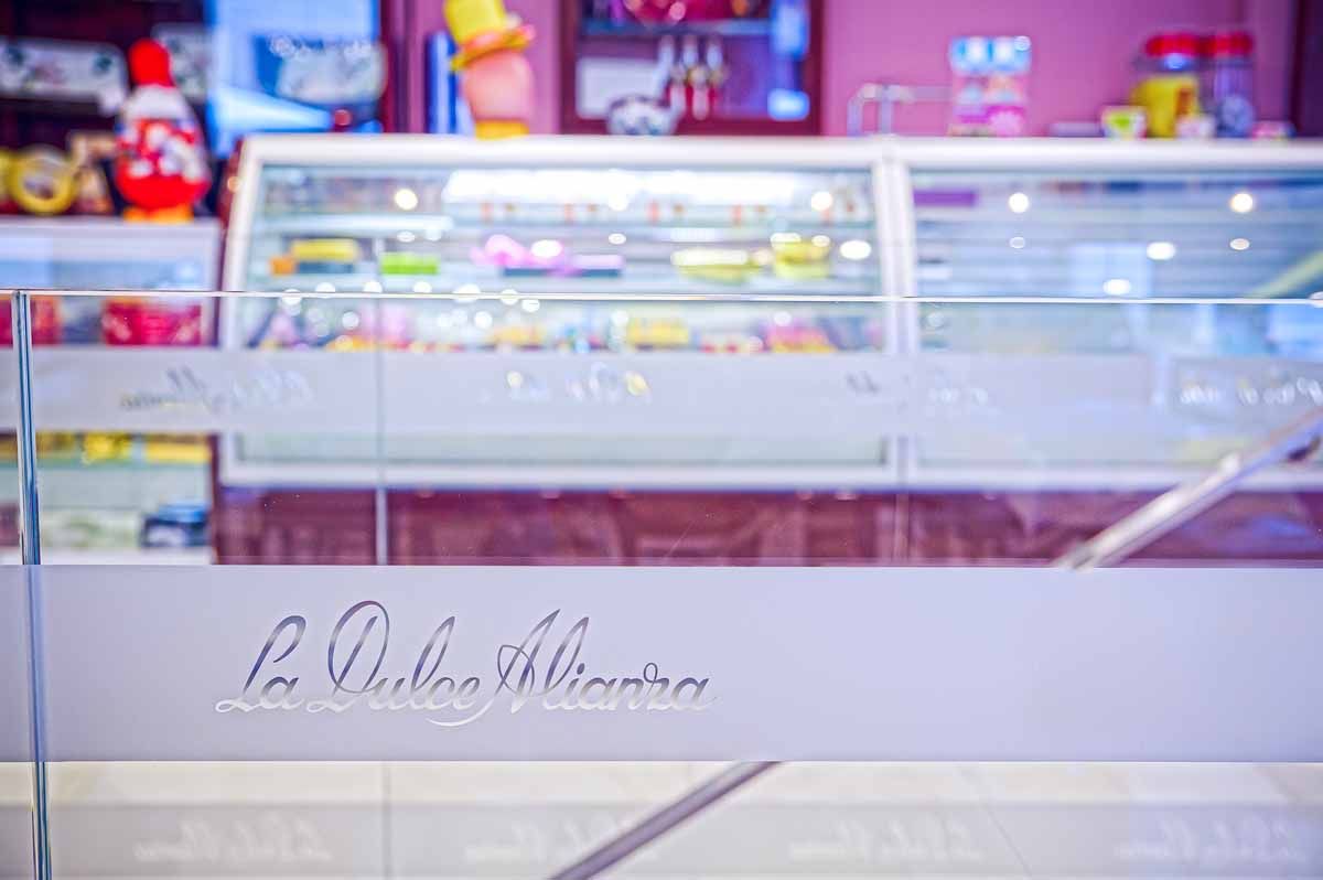 Vitrinas de cristal repletas de dulces en el interior de una tienda, con el nombre 