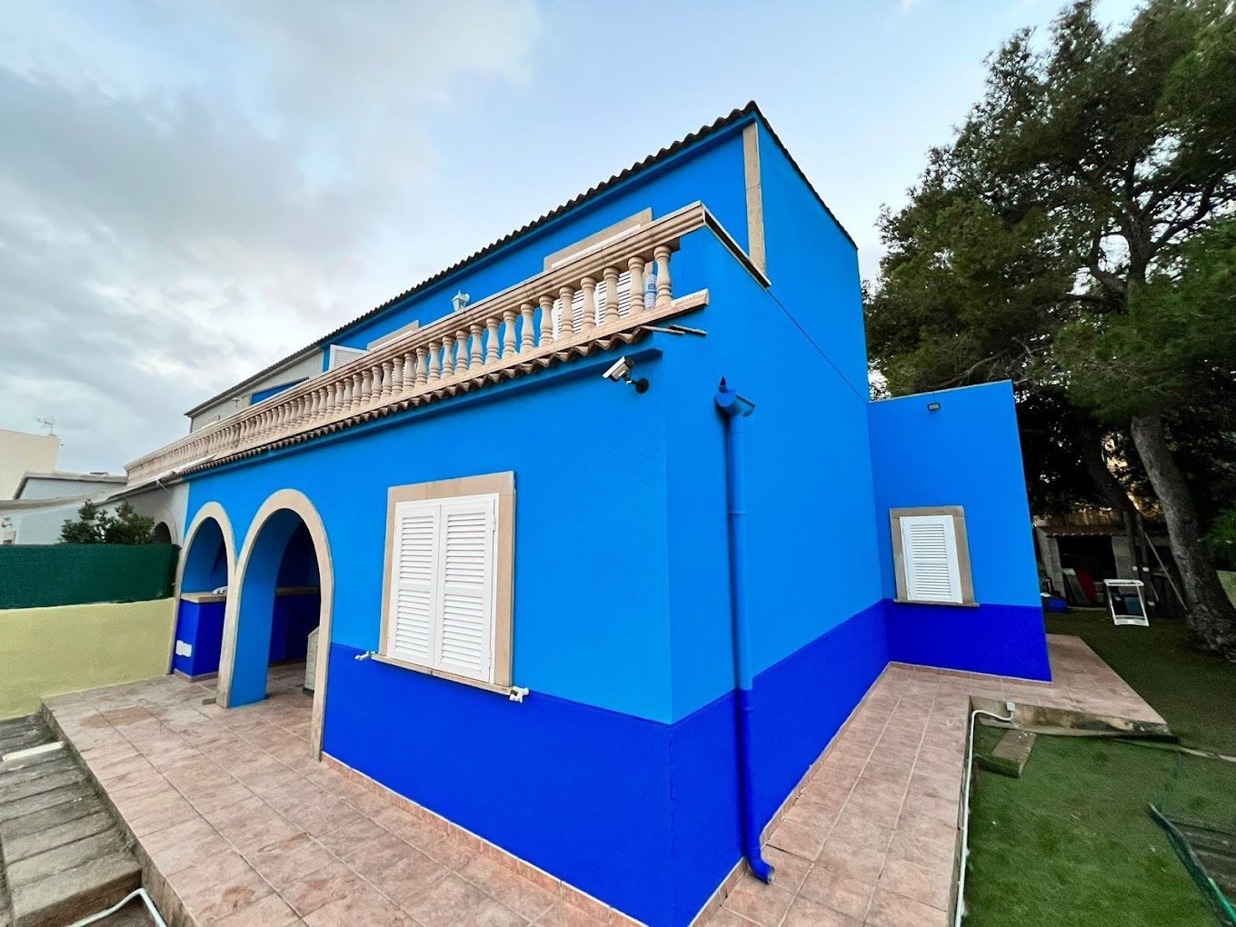 Una casa azul con balcón y escaleras