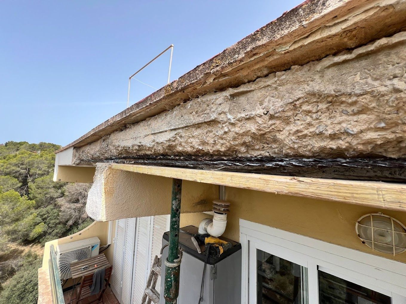 Un techo de un edificio con una escalera al costado.
