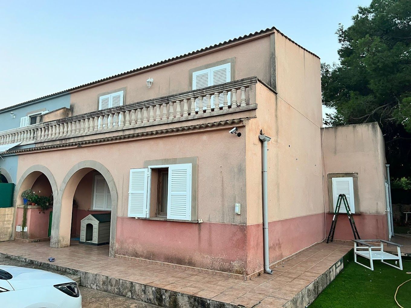Una casa con balcón y persianas en las ventanas