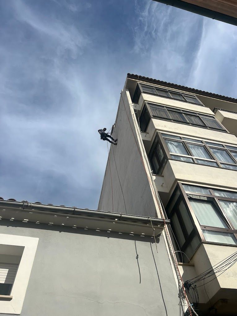Un hombre está subiendo por el costado de un edificio.