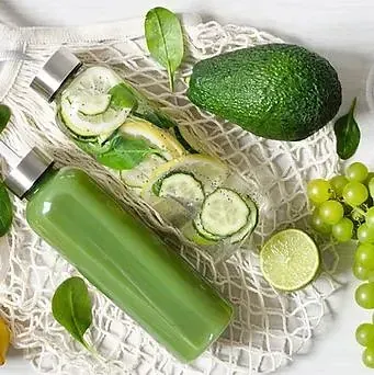 Un par de botellas llenas de verduras están encima de una mesa.
