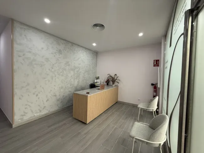 Una sala de espera con un escritorio y sillas y un extintor de incendios.