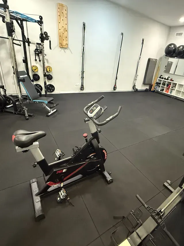 Una bicicleta de spinning está sentada en el medio de un gimnasio.
