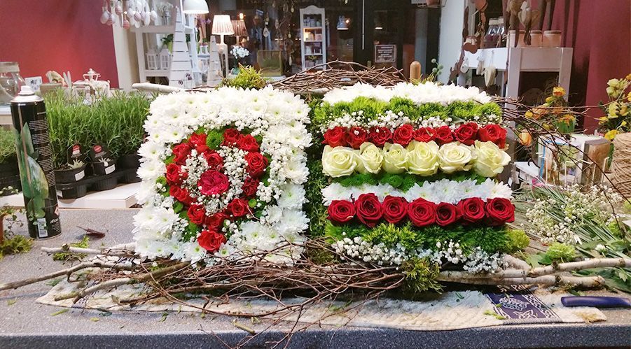 Blumen Liebe Woldegk - Elegantes Trauergesteck mit roten und weißen Rosen