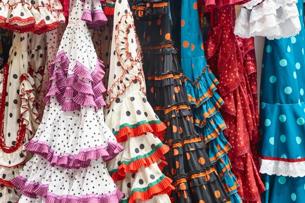 Vestidos de flamenco coloridos con volantes y lunares colgados en exhibición