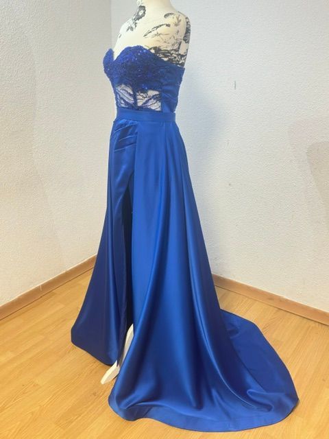 Ajuste de una prenda blanca sobre un maniquí negro en un taller de costura.