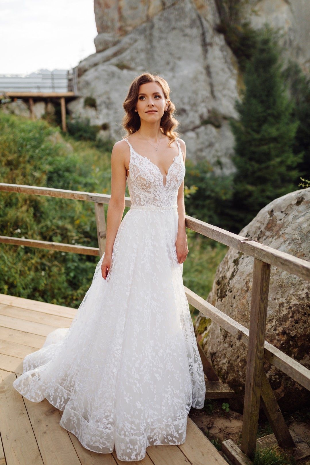 Una hilera de vestidos de novia blancos sobre maniquíes en una boutique con iluminación tenue.