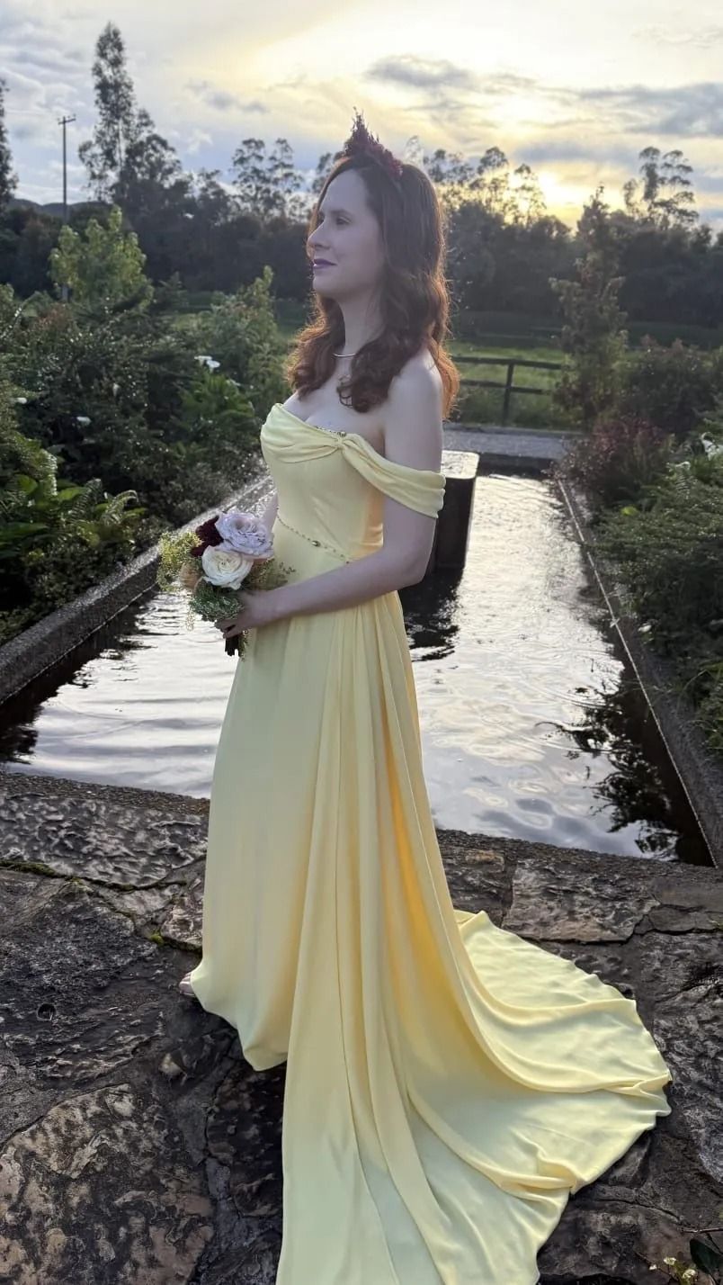 Dos vestidos color rosa empolvado y encaje colgados en perchas, con faldas de satén y corpiños bordados.