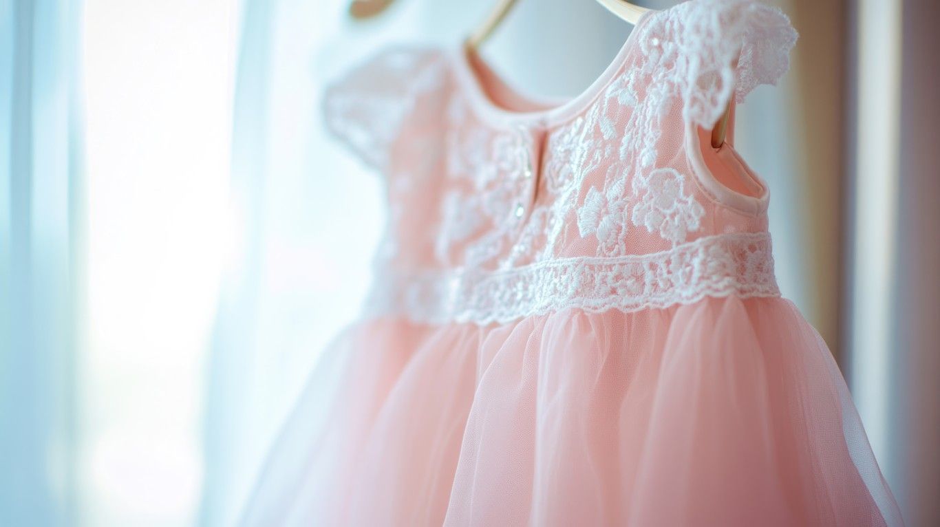 Vestido rosa de encaje colgado junto a una ventana luminosa