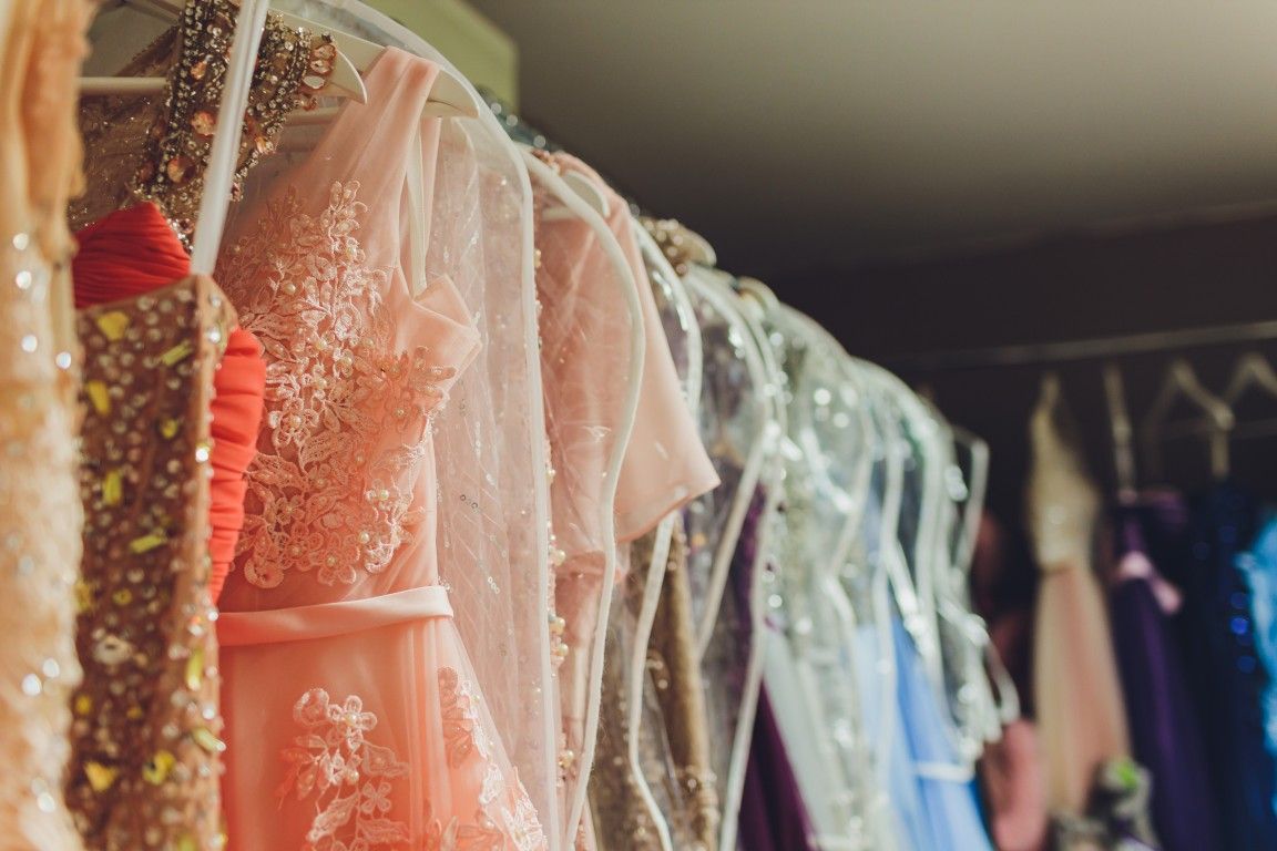 Vestidos en tonos pastel colgados en un perchero en una boutique.