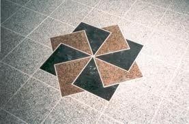 Suelo con dibujo decorativo de baldosas cuadradas de color marrón y negro dispuestas en forma de estrella.