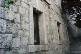 Edificio de piedra con ventanas y escaleras.
