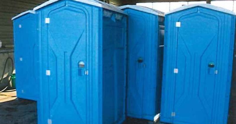 Un groupe de toilettes portables bleues sont alignées en rangée.