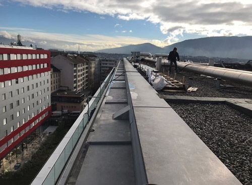 Un homme se tient debout sur le toit d'un immeuble.