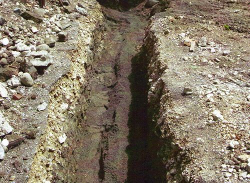 Une tranchée dans le sol avec des rochers et de la terre dedans