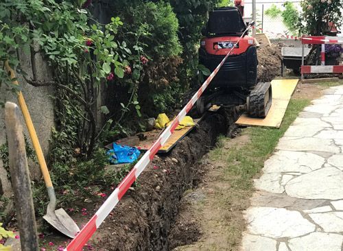 Une petite excavatrice est utilisée pour creuser un trou dans le sol.
