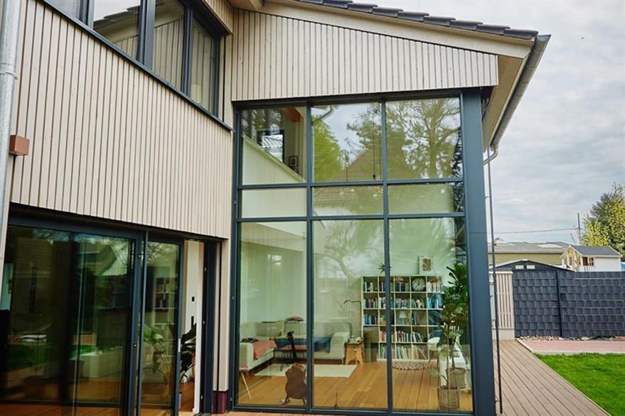 Ein Haus mit vielen Fenstern und einem Zaun im Hintergrund