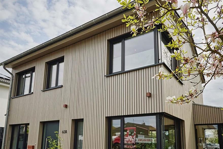 Ein Haus mit vielen Fenstern und einem Baum davor.