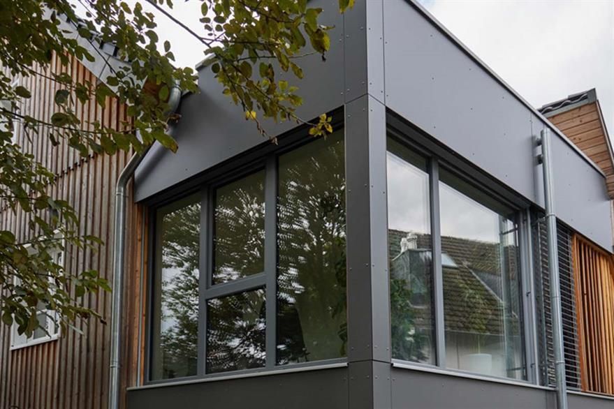 Ein Gebäude mit vielen Fenstern und einem Baum im Hintergrund.