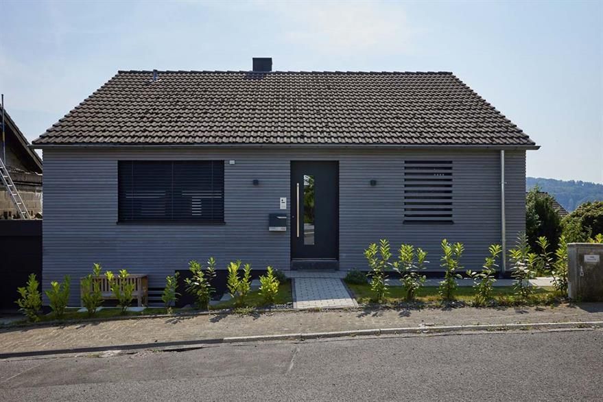 Ein kleines Haus mit Ziegeldach und schwarzer Tür