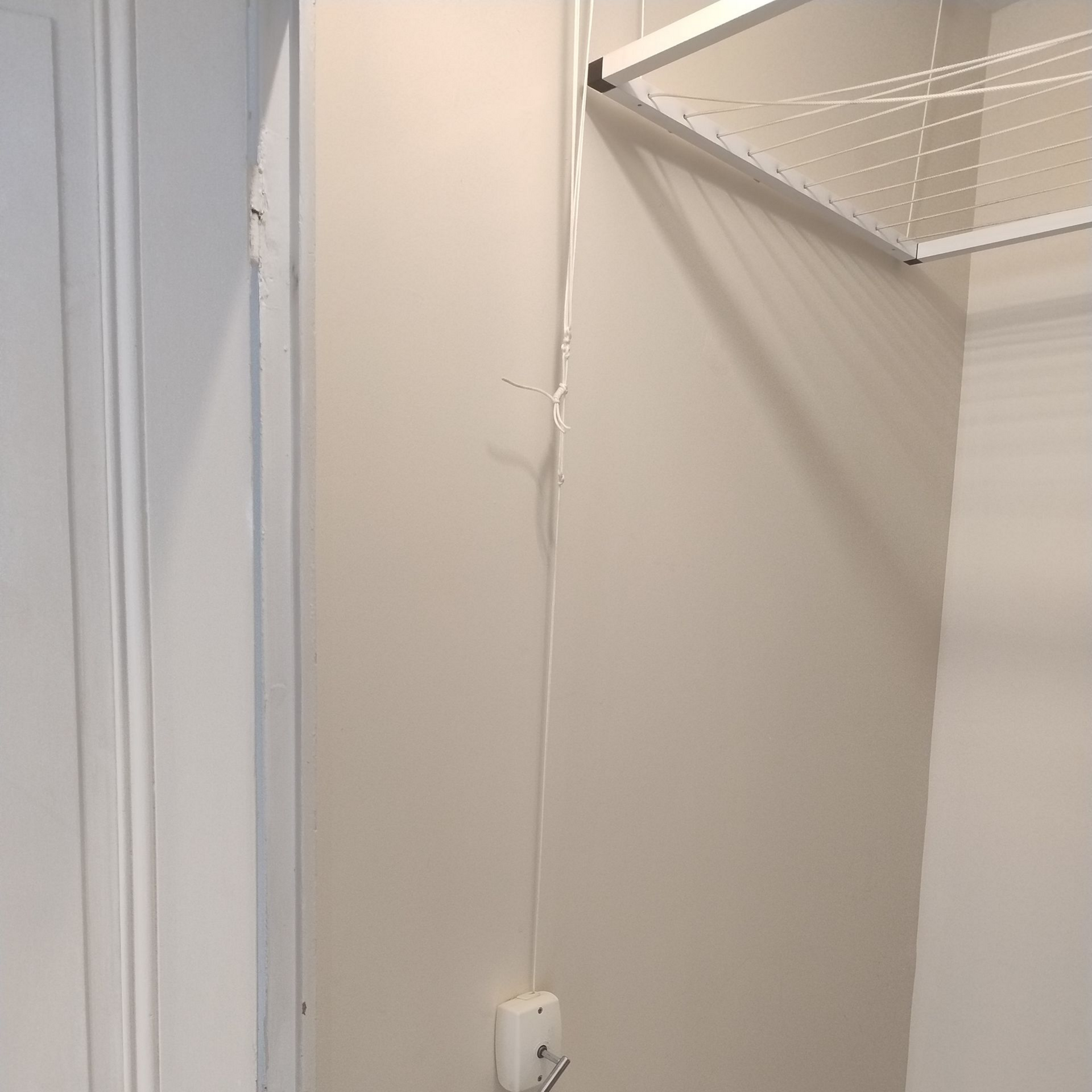 Un système de fixation et de tringles avec des cordages blancs reliés à une manivelle