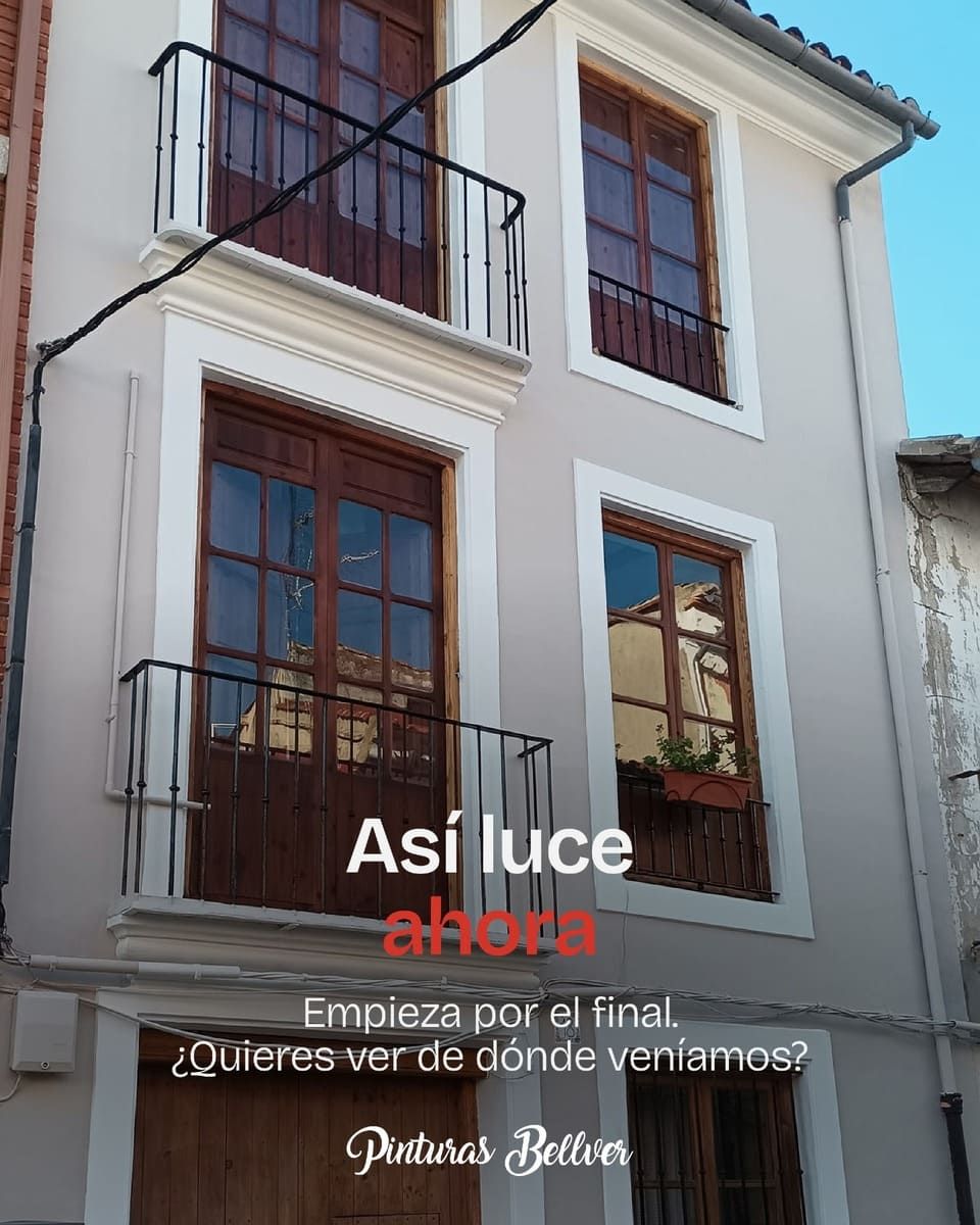 Fachada de casa blanca con balcones y grandes ventanales de madera, con texto promocional superpuesto.