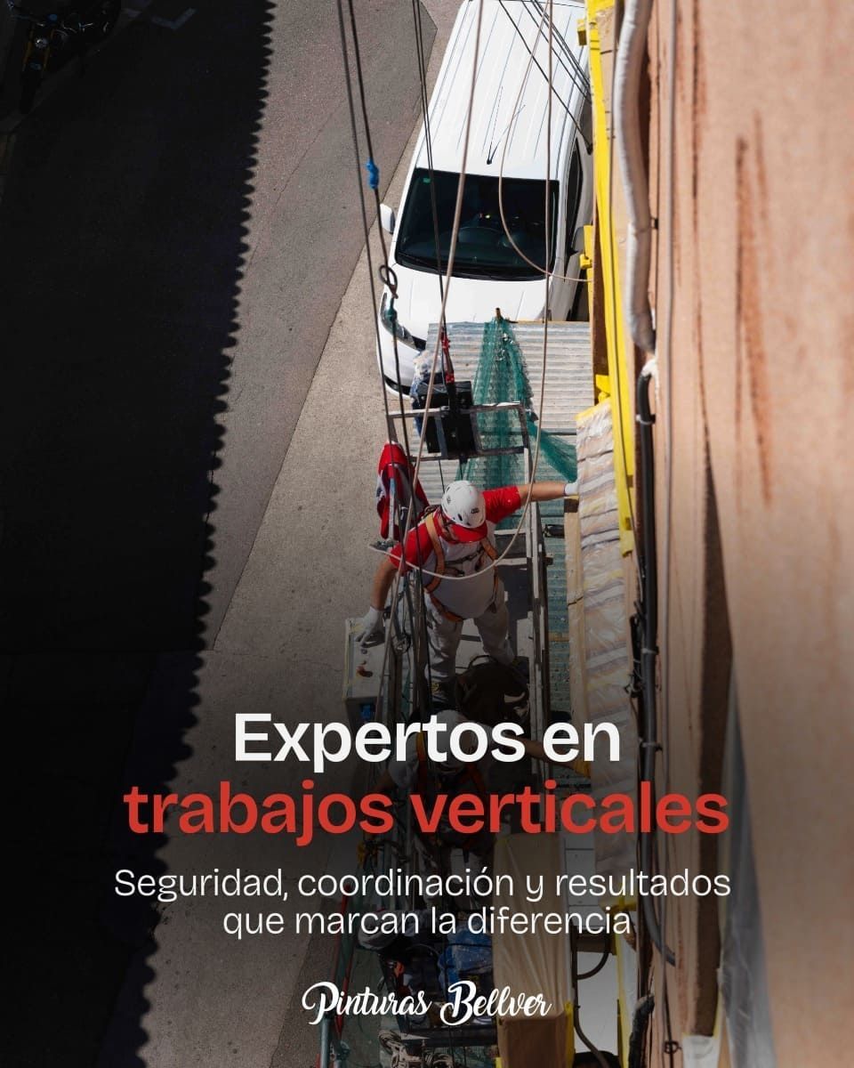 Trabajadores verticales en un edificio, con casco y arnés, junto a un anuncio de seguridad y coordinación.
