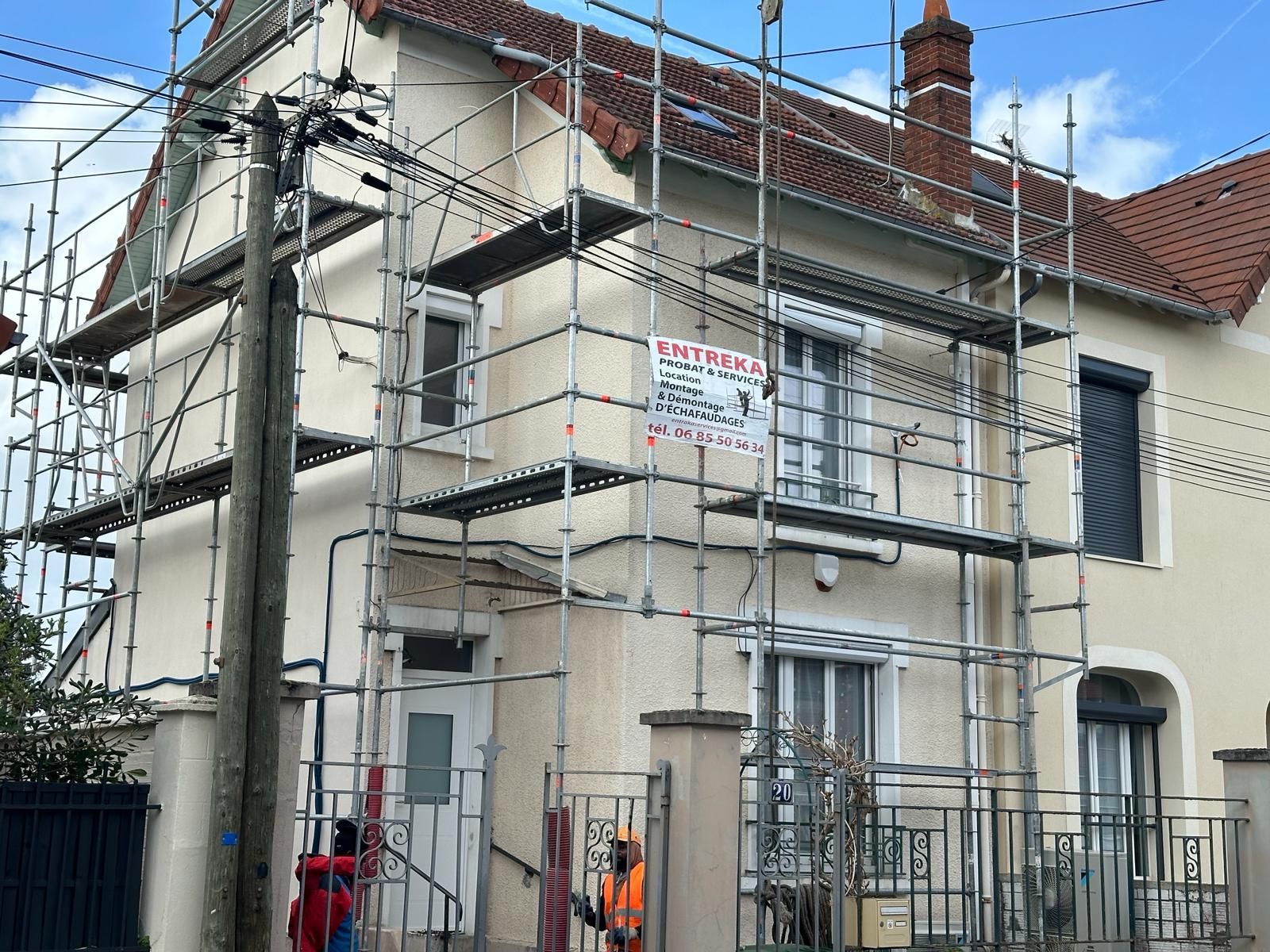 Échafaudages sur trois façades d'une maison blanche