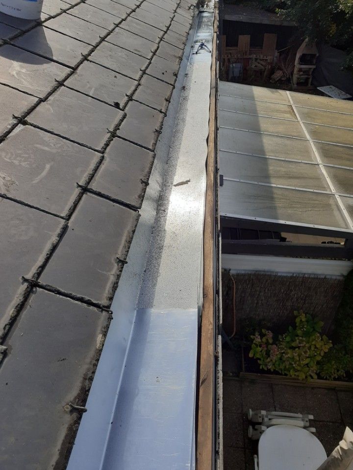 Gouttière contre une couverture en ardoise sombre