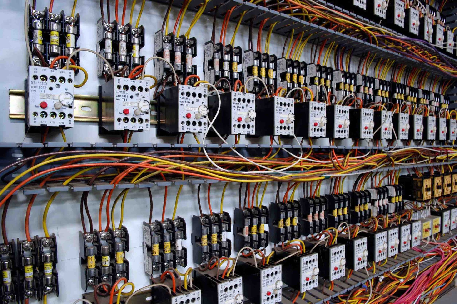 Un panel eléctrico muy grande del que salen muchos cables.