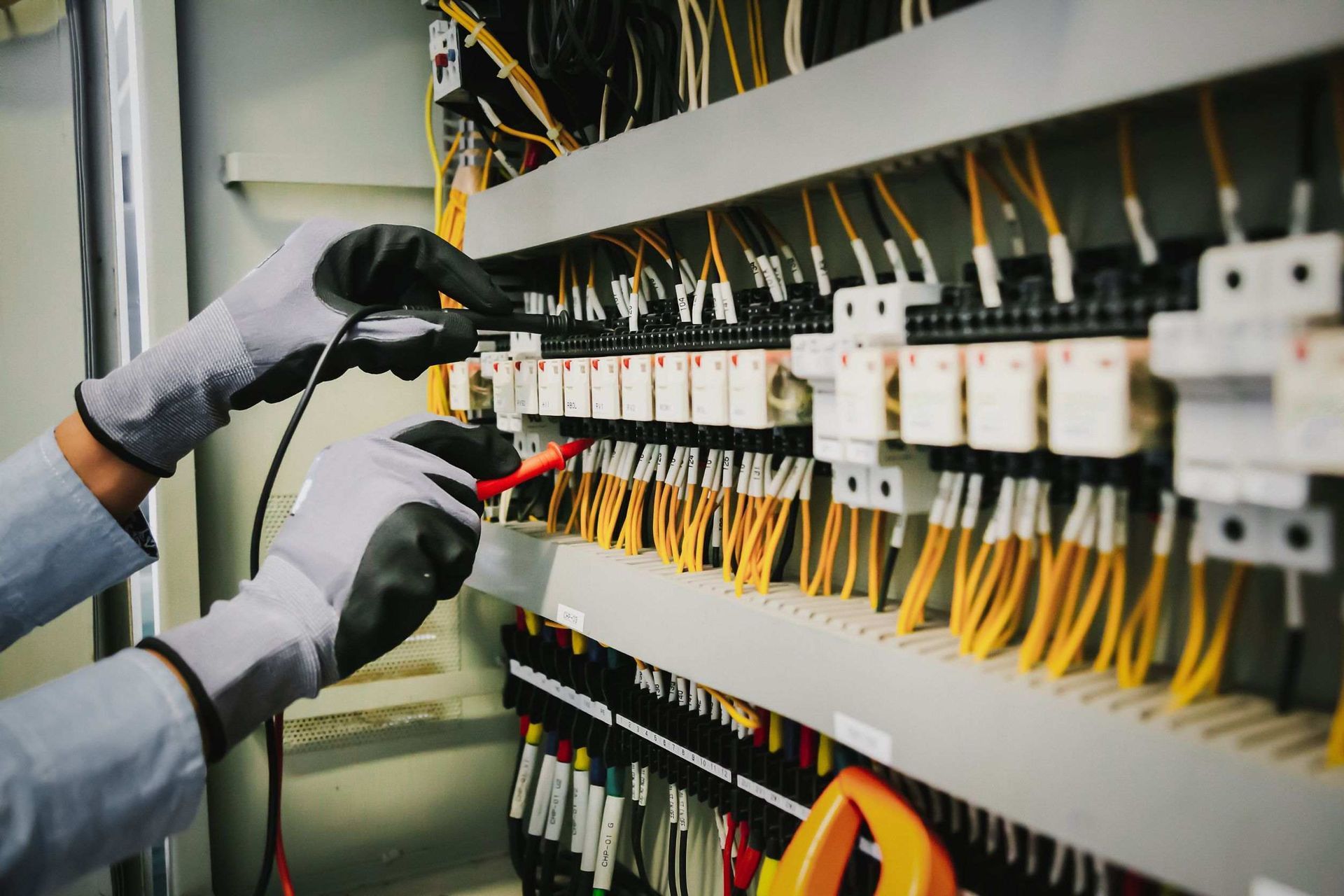Una persona está trabajando en un panel eléctrico con un voltímetro.