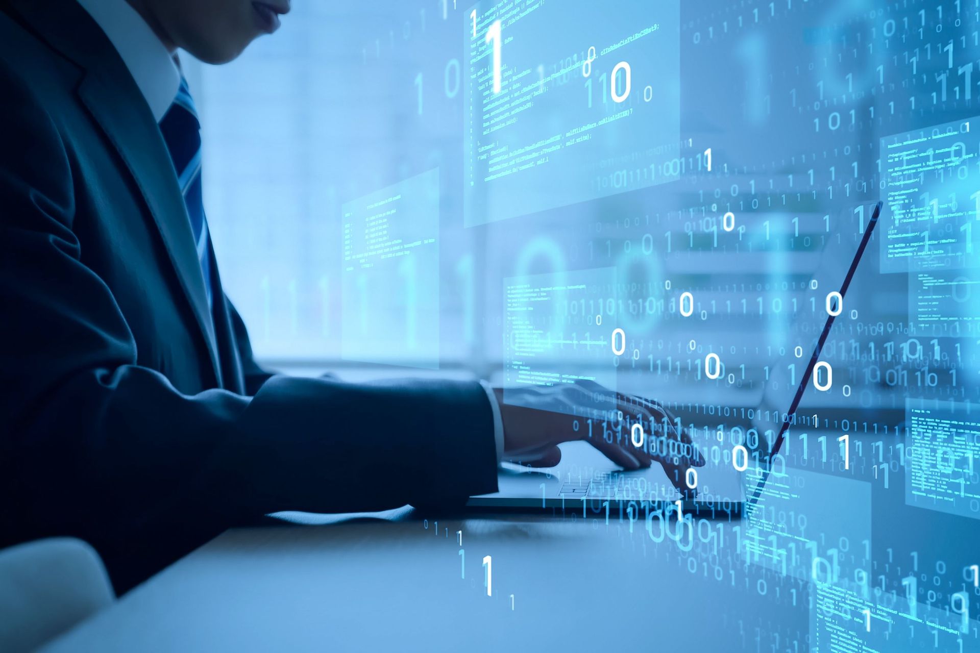 Un hombre con traje y corbata está usando una computadora portátil.