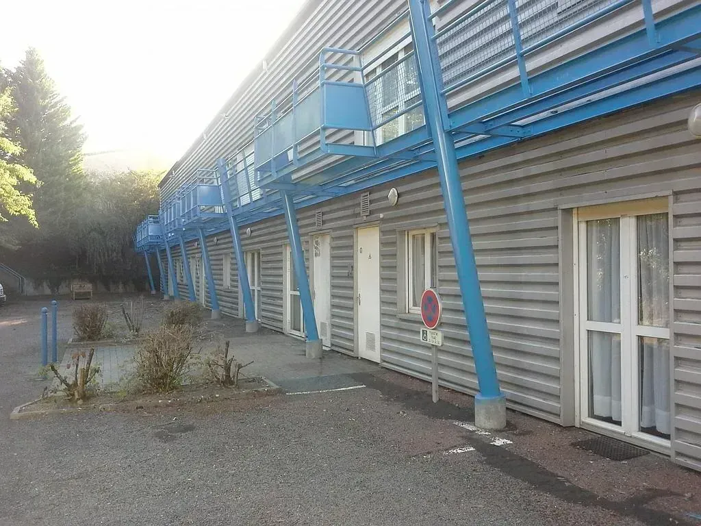 Bâtiment au bardage en zinc avec poteaux de soutien repeint en bleu