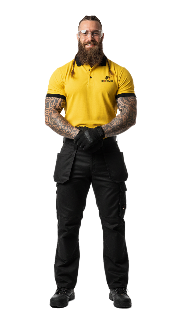 Hombre con uniforme de trabajo amarillo y negro, gafas de seguridad y guantes.