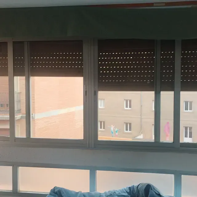 Una persona acostada en un sofá frente a una ventana