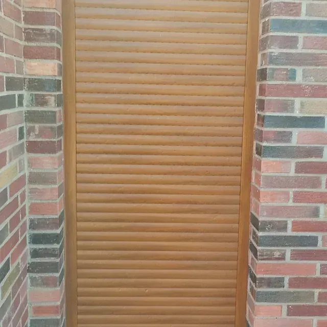 Una puerta de madera está entre dos paredes de ladrillo.