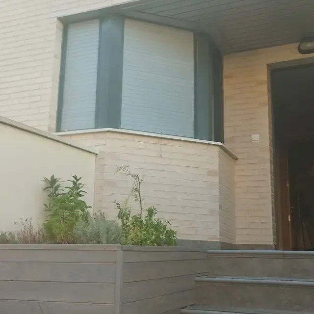 Un edificio de ladrillo con una ventana y escaleras que conducen a él.
