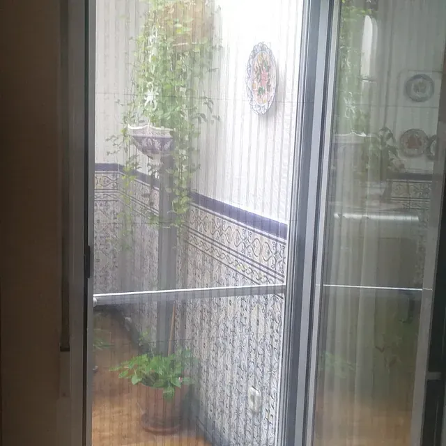 Una puerta corrediza de vidrio con mampara que da a un balcón.