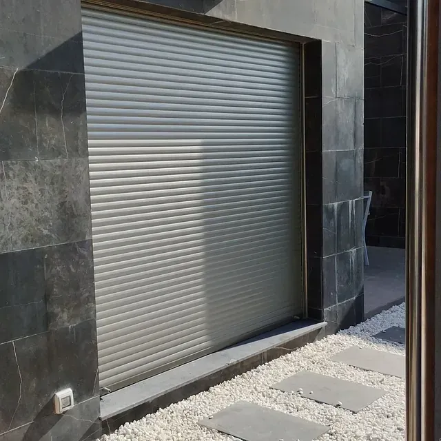 Una persiana blanca está en el costado de un edificio.