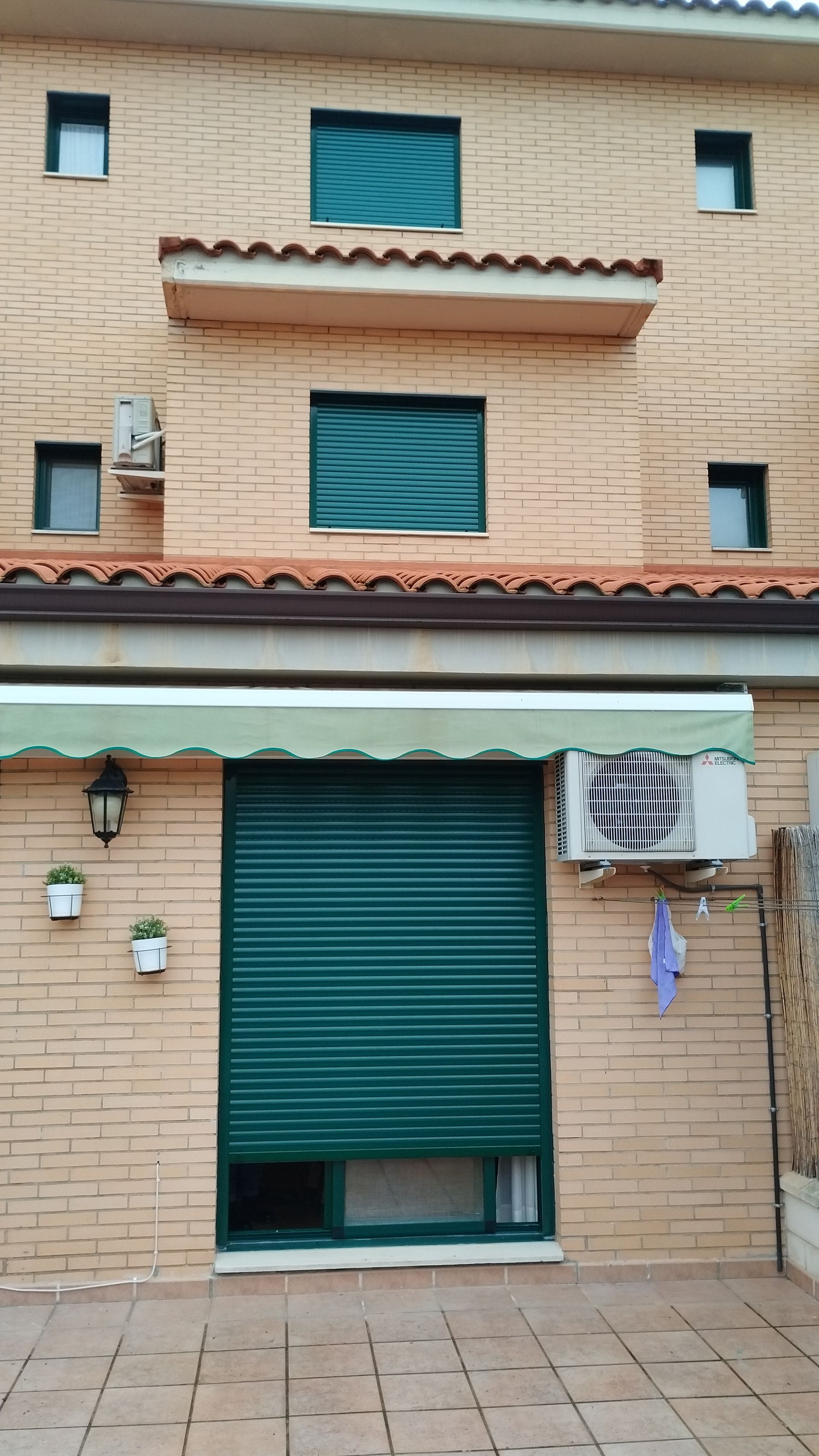 Un edificio de ladrillo con un toldo verde al costado.