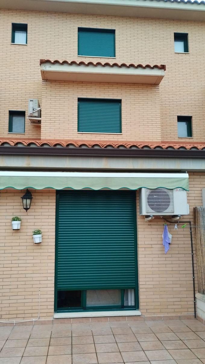 Un edificio de ladrillo con un toldo verde al costado.