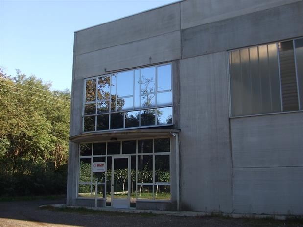 Un grande edificio in cemento con molte finestre e alberi sullo sfondo